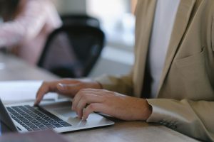 Professional typing on laptop at desk in modern office setting