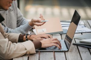 two people using a laptop