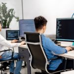 Software developers coding at computers in a modern office